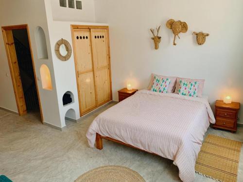 a bedroom with a bed and two lamps and a door at Casa Lucía in Sidi Ifni