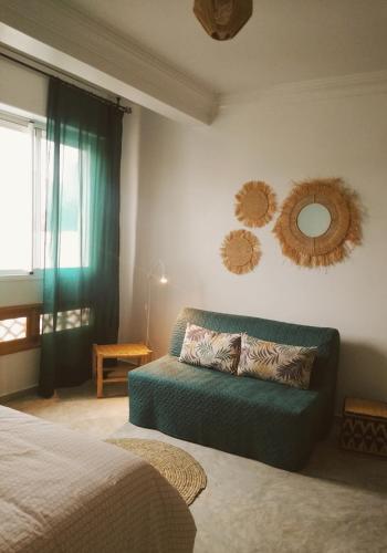 a bedroom with a couch and mirrors on the wall at Casa Lucía in Sidi Ifni
