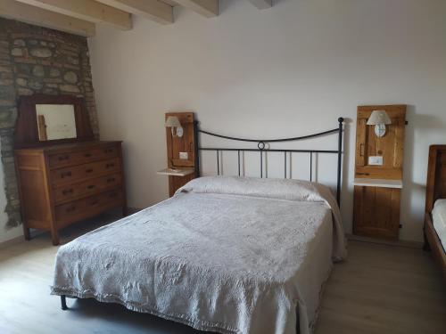 a bedroom with a bed and a dresser and a mirror at Casetta dei nonni in Pescantina