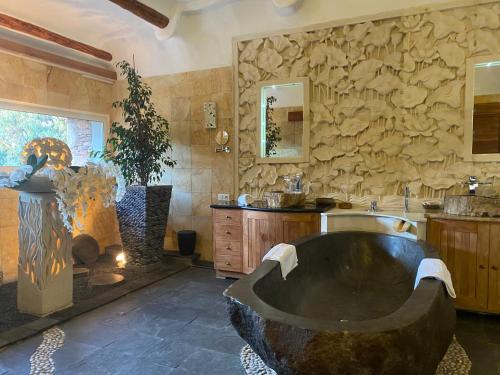 - une grande salle de bains avec une grande baignoire au milieu dans l'établissement Domaine de Piscia, à Figari