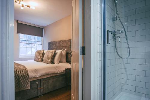 a master bathroom with a bed and a shower at 63 Chester Rows City Centre Apartment C by Rework Accommodation in Chester