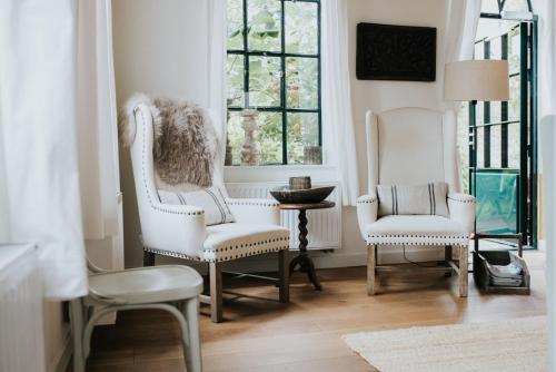 a living room with two chairs and a window at De vijgenhof in Appingedam