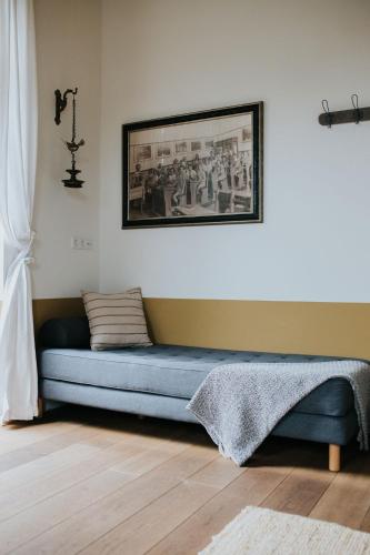 a blue couch in a room with a picture on the wall at De vijgenhof in Appingedam