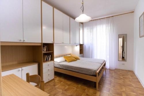 um quarto com uma cama e uma mesa em Luminoso appartamento con ampia terrazza em San Bartolomeo al Mare