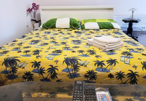Una cama con una manta amarilla con palmeras. en Apartman Starý Liskovec, en Brno