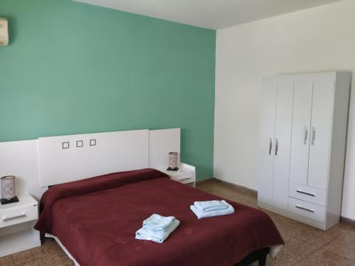 een slaapkamer met een bed met twee handdoeken erop bij DOÑA OLGA in Minas