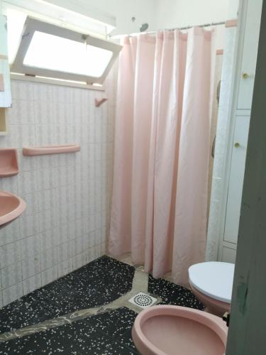 y baño con aseo rosa y ducha. en DOÑA OLGA, en Minas