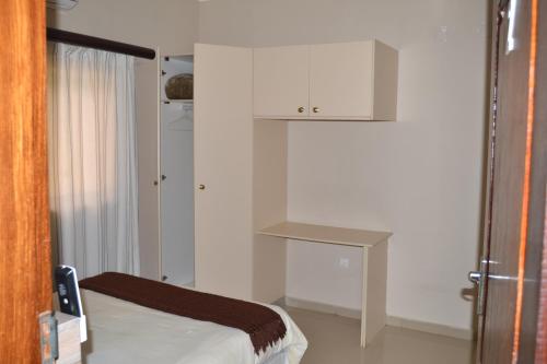 a small room with a bed and a table at Ponta View Hotel in Ponta do Ouro