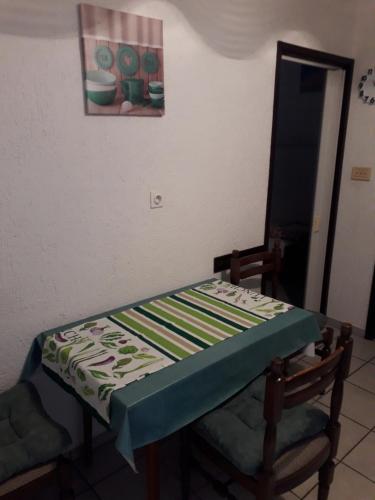a table and a chair with a quilt on it at Apartments Lidija in Pag