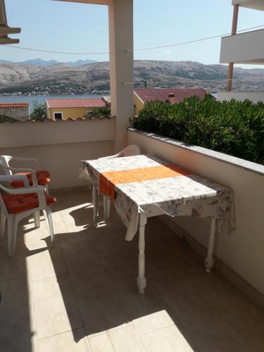 a table and chairs on a balcony with a view at Apartments Lidija in Pag