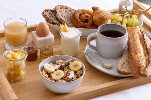 a breakfast tray with a plate of breakfast foods and a cup of coffee at Hôtel Beige in Paris