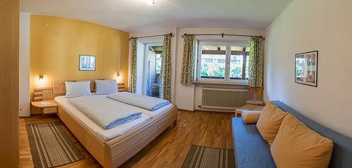 - une chambre avec un grand lit et un canapé dans l'établissement Gruggerhof, à Seefeld in Tirol