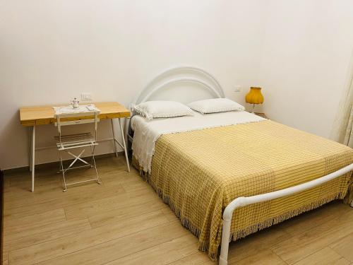 1 dormitorio con cama, mesa y escritorio en CASA MIA MALVA, en Riccò del Golfo di Spezia