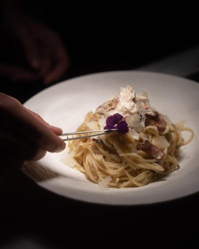 a person is eating pasta on a white plate at Snob Athens in Athens