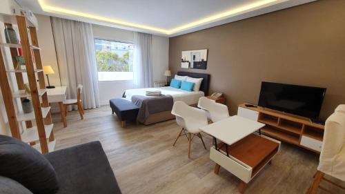 a hotel room with a bed and a living room at Lucania Palazzo Hotel in Comodoro Rivadavia