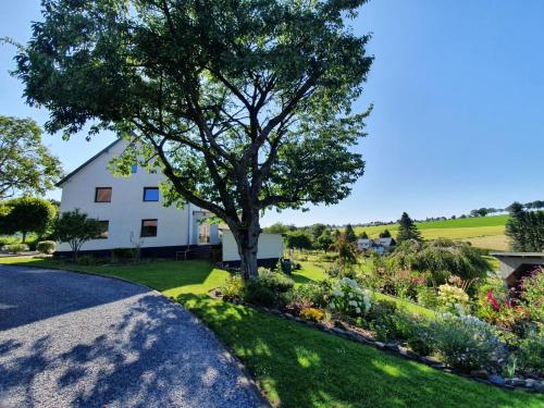 ein Haus mit einem Baum und einem Garten in der Unterkunft Eifel-Ferienhaus Landblick in Hürtgenwald