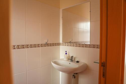 a white bathroom with a sink and a mirror at O DRAGOEIRO da Madalena! in Porto Santo