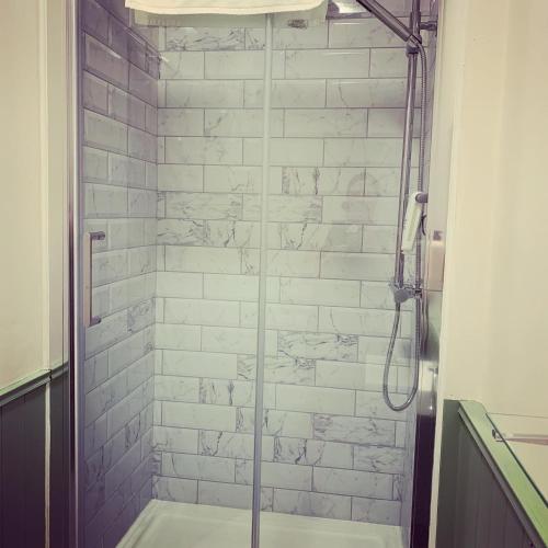a bathroom with a shower with a glass door at Black Bull Inn in Haworth