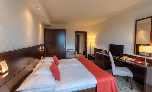 a hotel room with a bed and a desk at Hunguest Hotel Gyula in Gyula