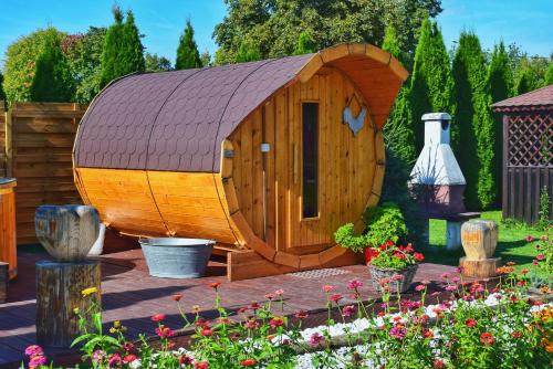 a small wooden dog house in a garden at Leśny Zakątek Uroczysko in Rychtal