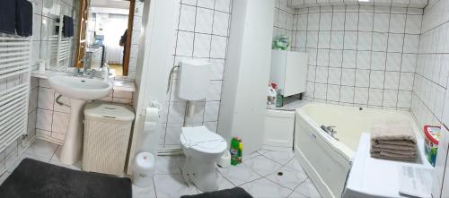 a bathroom with a sink and a toilet and a tub at Vio apartament in Zalău