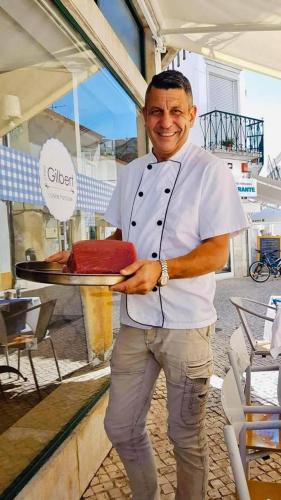 a man is holding a cake on a tray at The Seyyida Hotel and Spa in Zanzibar City