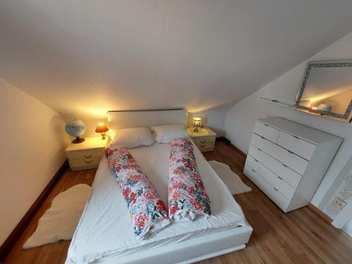 Un dormitorio con una cama blanca con almohadas. en Ferienwohnung Krämer, en Bönnigheim