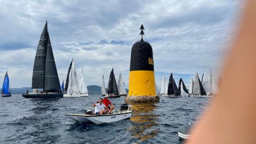 un groupe de voiliers dans l'eau avec un phare dans l'établissement VOILES ST TROPEZ APARTEMENTS, à Saint-Tropez
