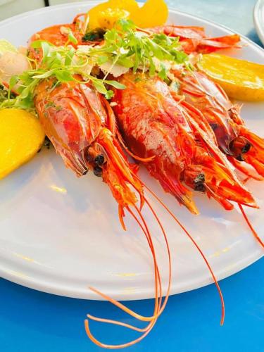 a white plate of food with crabs and vegetables at The Seyyida Hotel and Spa in Zanzibar City
