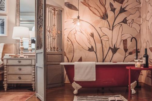 a bathroom with a red tub and a flower wallpaper at Tianjin G'apartment - Five Great Avenues in Tianjin