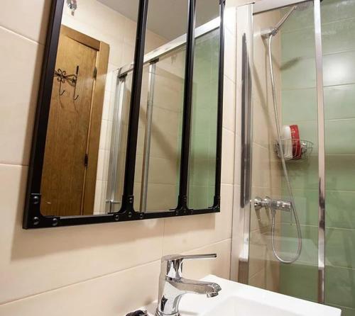 a bathroom with a sink and a mirror and a shower at APARTAMENTOS LA VIEJA IMPRENTA in Sigüenza