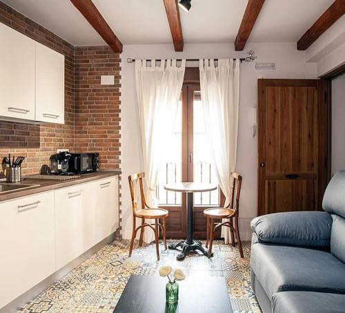 a kitchen and living room with a table and chairs at APARTAMENTOS LA VIEJA IMPRENTA in Sigüenza