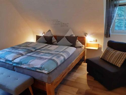 een slaapkamer met een bed en een stoel erin bij Ferienwohnung Zur Basemicke in Schmallenberg