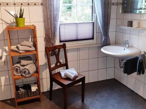 een badkamer met een wastafel, een stoel en een wastafel bij Ferienwohnung Zur Basemicke in Schmallenberg