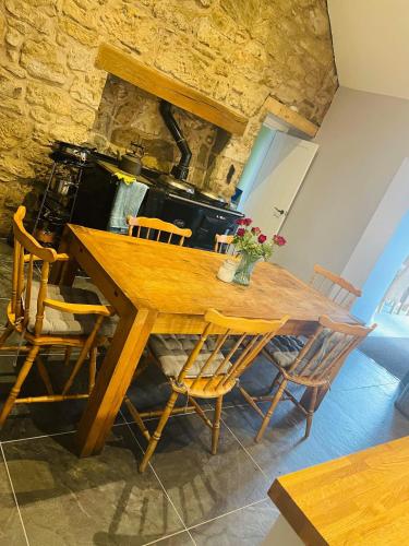 a dining room with a wooden table and chairs at Remus B&B in Lochgelly