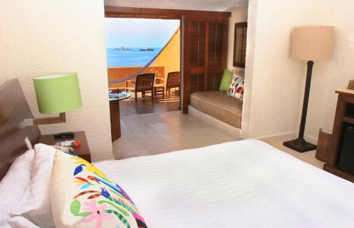 a bedroom with a bed and a view of the ocean at Las Brisas Ixtapa in Ixtapa