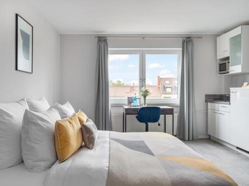 een slaapkamer met een bed, een bureau en een raam bij numa I Oben Apartments in Frankfurt am Main