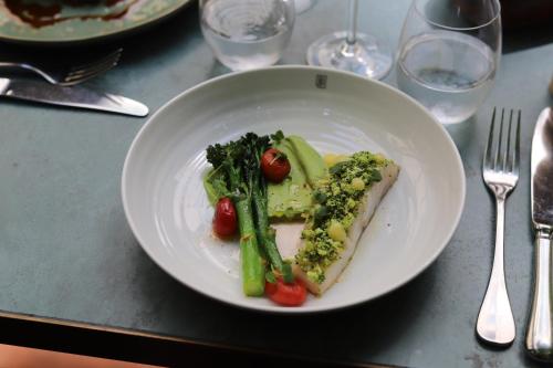 a plate of food with broccoli and vegetables on a table at Maison Bréguet in Paris