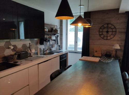 a kitchen with black cabinets and a counter top at Le Clos des Marmottes in Cauterets