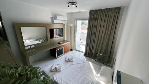 a hotel room with a bed and a television at Fotoxenia Luxury Apts in Paralimni