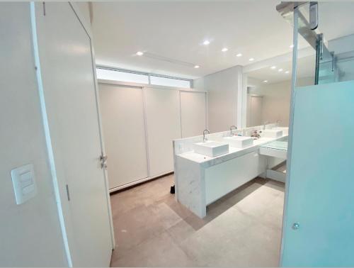 a bathroom with two sinks and a mirror at Luxo e pé na areia in Parnamirim