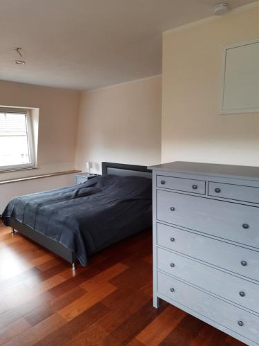 a bedroom with a bed and a dresser at Apartment im OG zwischen See und Wald mit großem Garten in Bestensee