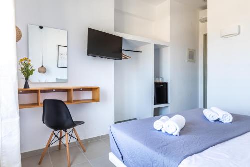 a bedroom with a bed with a chair and a desk at Uncle John's Guesthouse in Skopelos Town