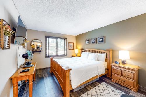 Dormitorio con cama, escritorio y TV en Sunrise 8, en Mammoth Lakes