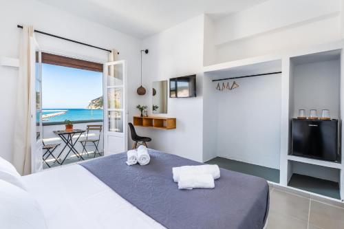 a bedroom with a bed with a view of the ocean at Uncle John's Guesthouse in Skopelos Town