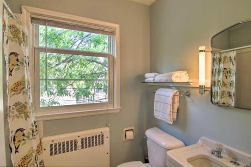a bathroom with a window and a toilet and a sink at Mid-Century Bozeman Townhome about 1 Mi to Dtwn! in Bozeman