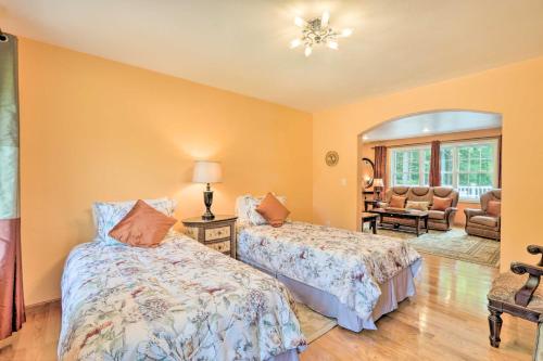 a bedroom with two beds and a living room at Granby Home with Deck Less Than half Mi to Aldrich Lake! in Granby