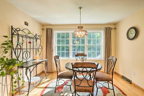 a dining room with a table and chairs and a clock at Granby Home with Deck Less Than half Mi to Aldrich Lake! in Granby