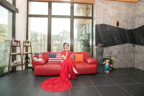 a girl in a red dress sitting on a red couch at GOD’S Queen Esther in Nangan