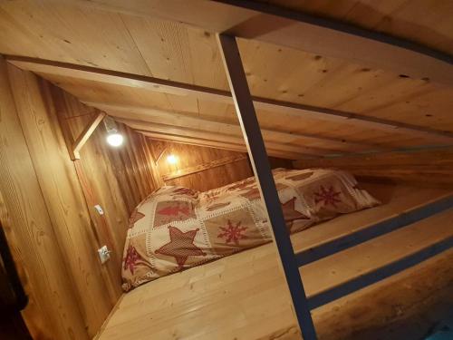 Ce lit superposé se trouve dans une cabane en bois dotée d'un plafond. dans l'établissement Esprit Myrtille Balcon Vue lac, à Gérardmer